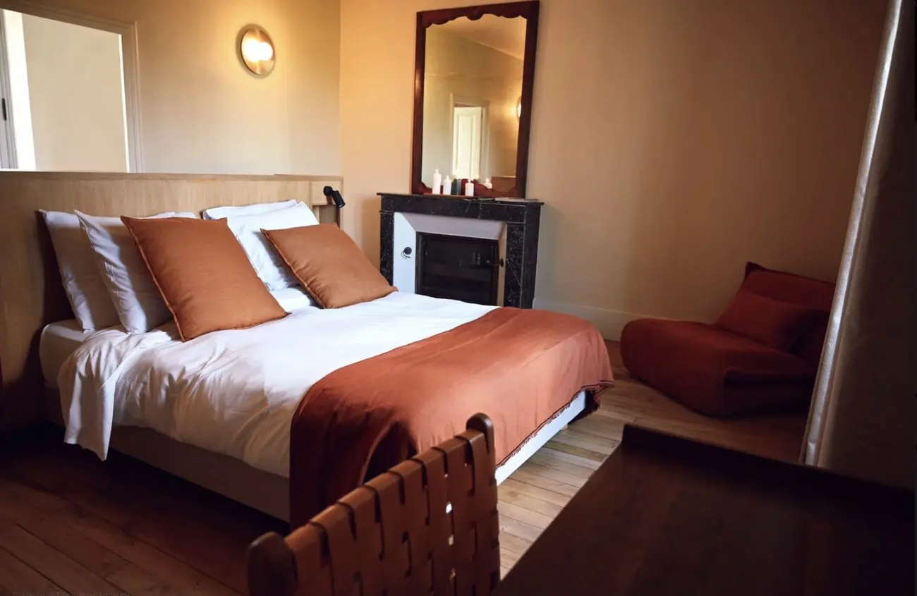Chambre Supérieure avec cheminée, miroir et fauteuil bas