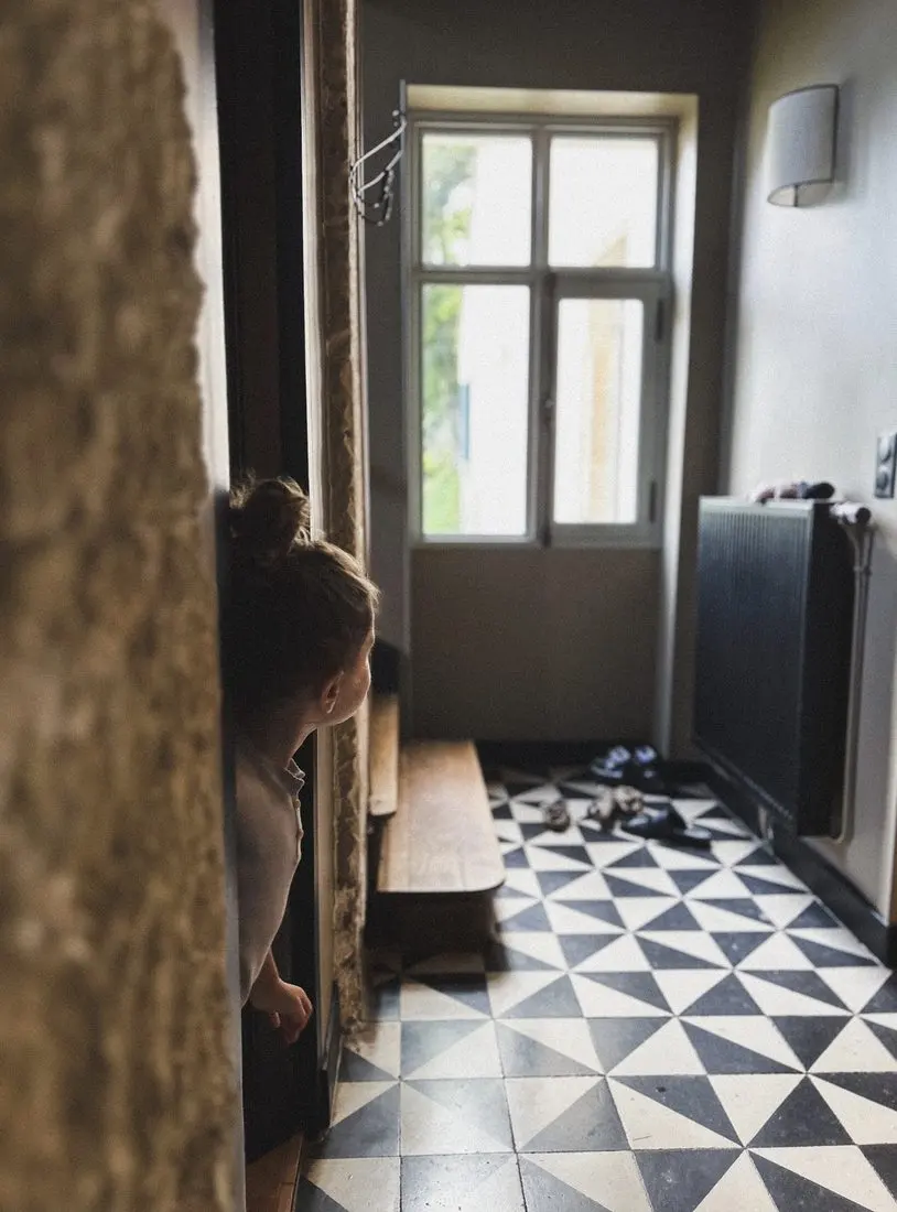 Un enfant dans l'entrée aux carreaux de ciment
