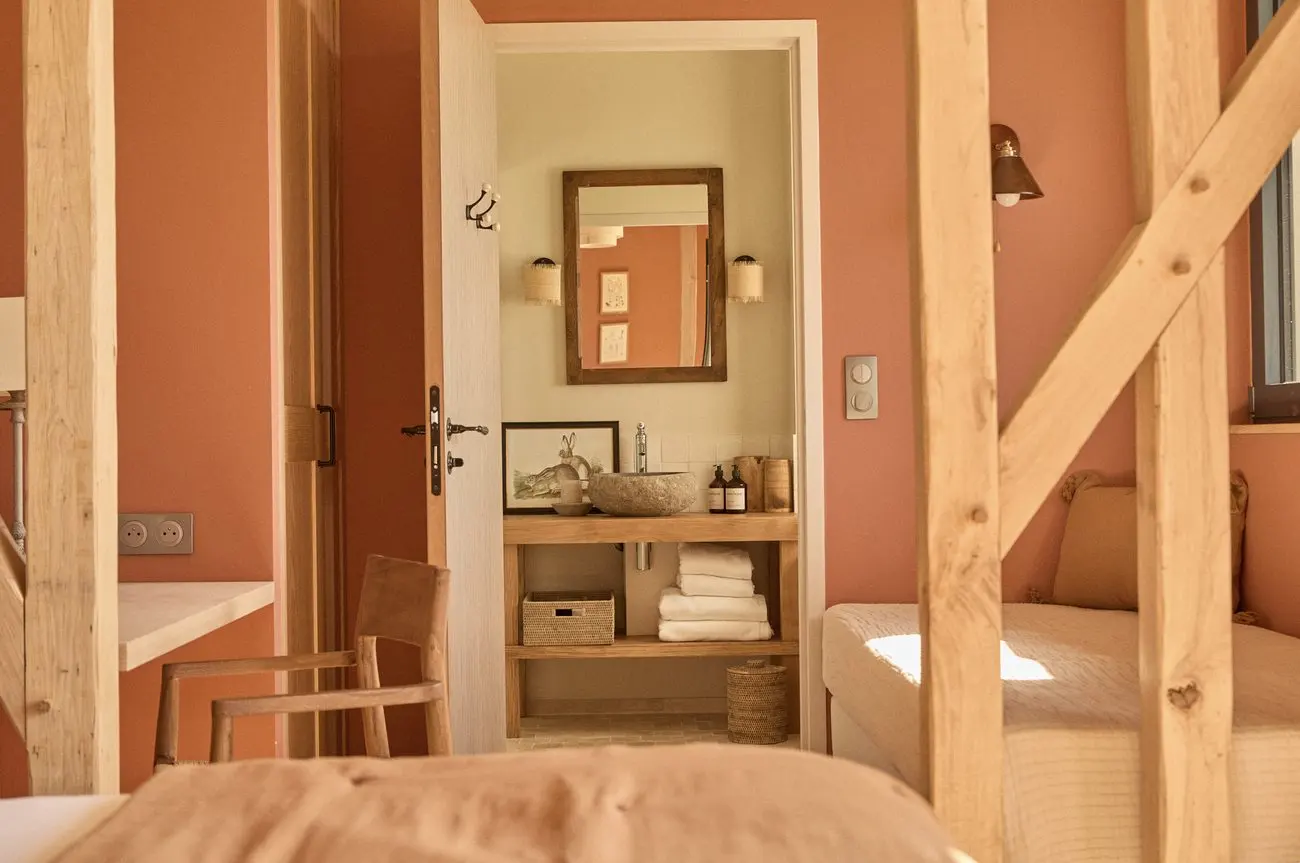 Chambre terracotta, vue sur la salle de bain entre les colombages