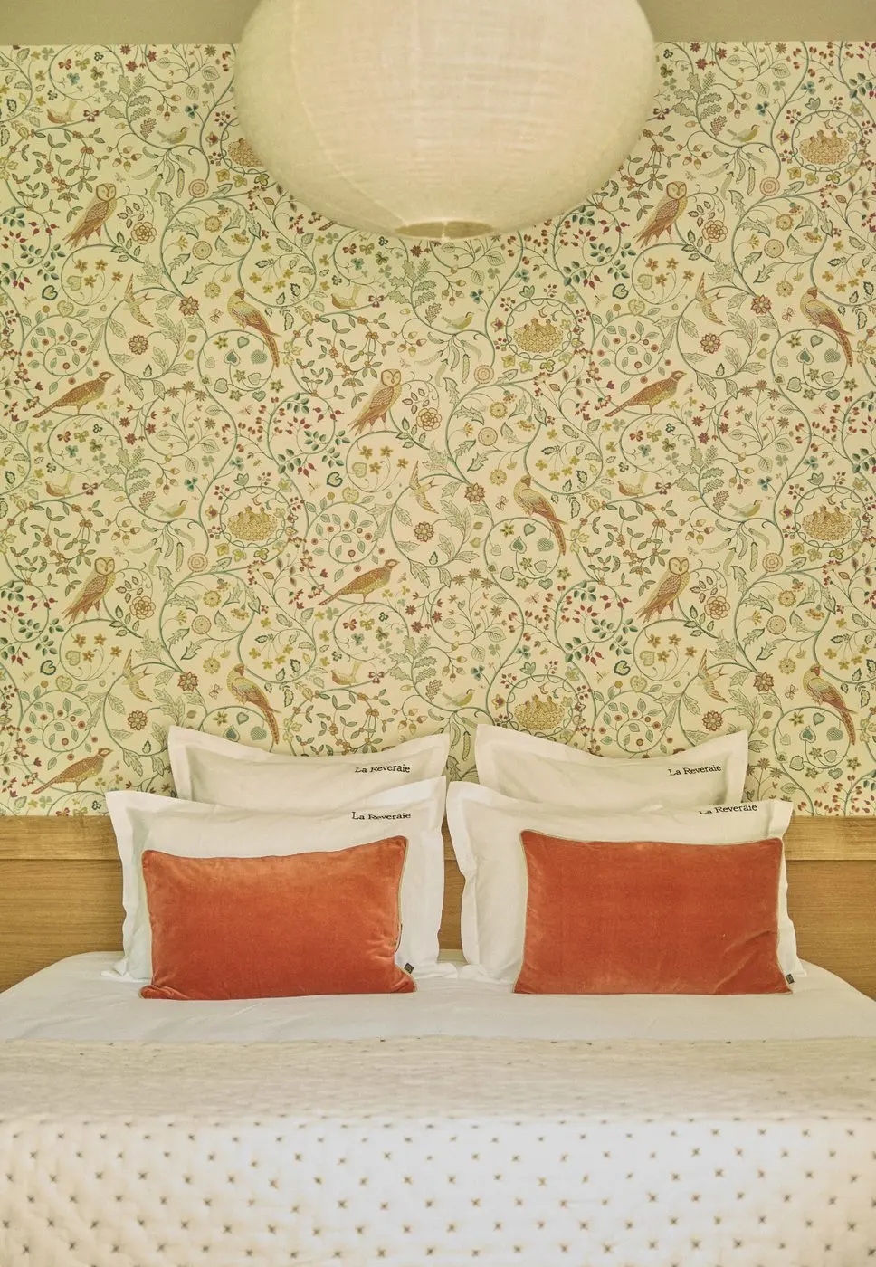 Détail du papier peint aux oiseaux et du linge brodé La Rêveraie