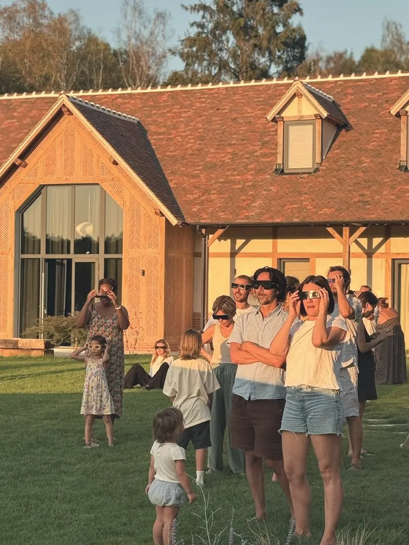 Parents et enfants observent une éclipse sur la pelouse