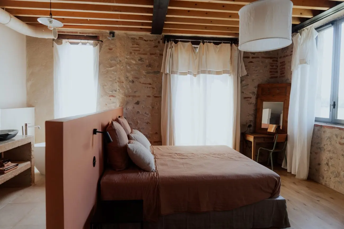 Chambre du gîte, lit rose et salle de bain ouverte